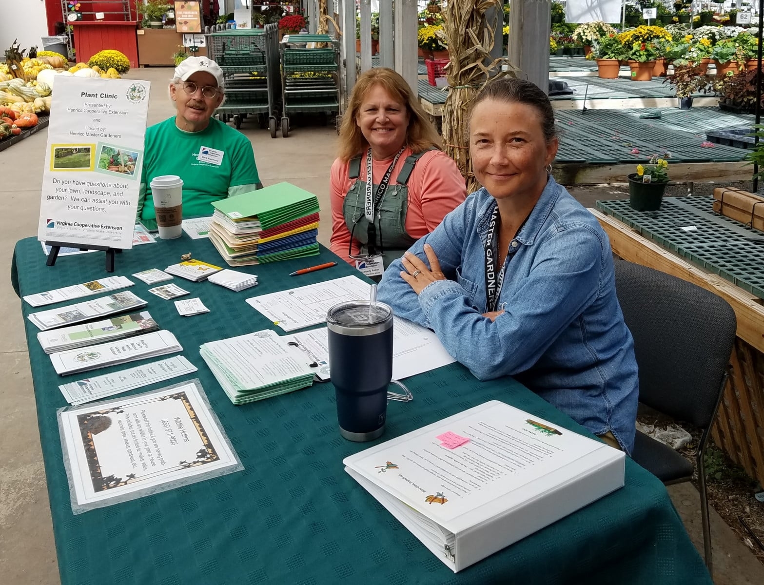 Three Henrico Master Gardeners sitting at a table with reference materials.